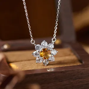 Macro detail of silver necklace with sunflower citrine and clear gemstone pendant