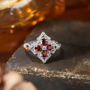 Close-up detail of a vintage s925 silver ring featuring red garnets and white stones.