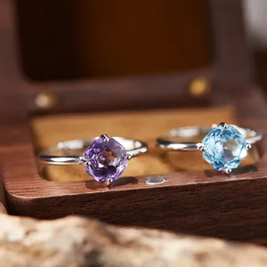 Detailed view of S925 silver rings with hexagonal amethyst and blue topaz gems.