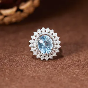 Vue macro d'une bague style tournesol avec topaze bleue ovale et anneau en argent s925