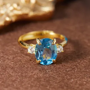 Gros plan d'une bague de luxe en topaze bleue suisse avec une grande pierre ovale bleue