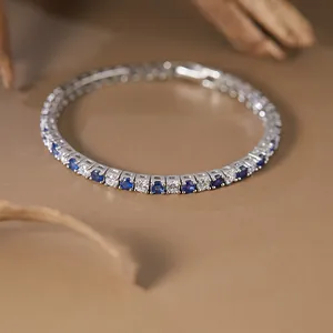 Macro view of elegant S925 silver tennis bracelet with blue sapphires and cubic zirconia.