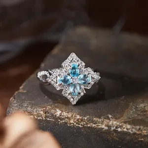 Detailed close-up of a vintage s925 silver ring featuring blue gemstones in floral cross design
