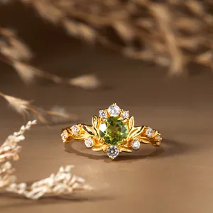 Vue macro d'une bague vintage en péridot avec détails de feuilles dorées sur argent s925
