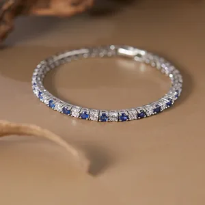 Macro detail of a S925 silver tennis bracelet featuring blue sapphire and white stones