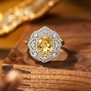 Détail macro d'une bague citrine jaune avec un motif floral en dentelle d'argent