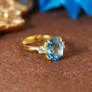 Vue rapprochée d'une bague en argent S925 dorée avec une topaze bleue suisse