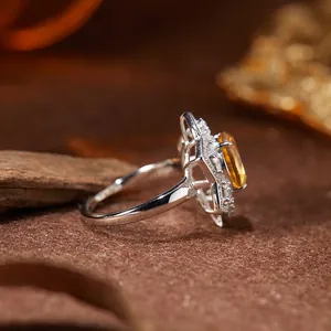 Close-up side view of a silver ring featuring a sparkling yellow citrine gemstone