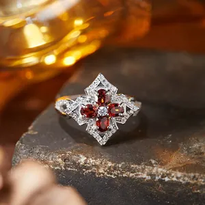 Macro detail of vintage S925 silver ring with red garnet-like stones in clover pattern