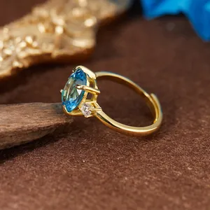 Détail en gros plan d'une bague en argent S925 plaqué or avec topaze bleue suisse
