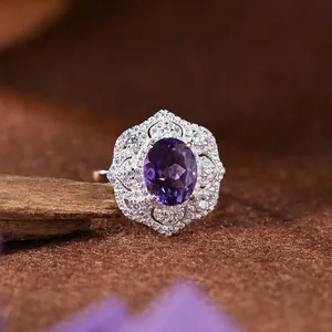 Gros plan d'une bague en argent S925 avec améthyste ovale et halo de cristaux style dentelle.
