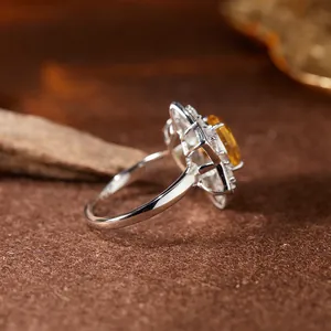 Macro view of sterling silver ring with natural citrine stone and floral halo setting