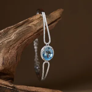 Close-up of elegant S925 silver bracelet featuring oval blue topaz and pavé stones