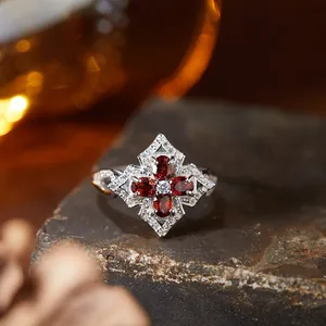 Close-up of a vintage s925 silver ring with red garnet gemstones on stone background