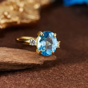 Vue rapprochée d'une bague en argent S925 avec topaze bleue suisse ovale et dorée