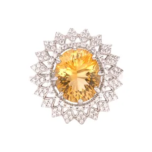 Gros plan d'une bague tournesol en argent avec une citrine jaune ovale au centre.