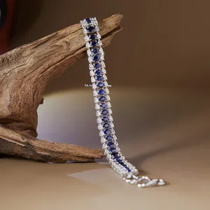 Gros plan détaillé d'un bracelet en argent S925 avec saphirs bleus et zircons sur du bois.