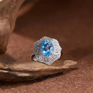 Vue macro d'une bague en argent S925 avec topaze bleue et détails en dentelle ajourée.
