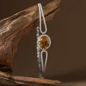 Detailed macro view of an oval citrine gemstone bracelet in silver with halo setting