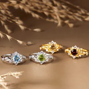 Gros plan de quatre bagues vintage serties de citrine péridot grenat et topaze naturelles