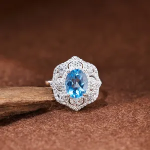 Vue macro détaillée d'une bague en argent S925 avec une topaze bleue ovale éclatante.