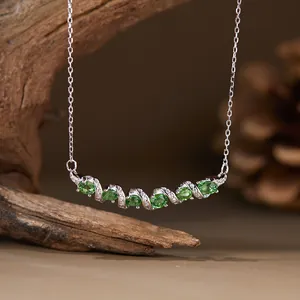 Primer plano de collar de plata S925 con piedras de tsavorita verde en diseño curvo