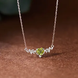 Gros plan sur le pendentif péridot en forme de cœur avec motifs feuilles en argent 925.