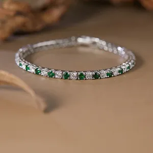 Macro view of S925 silver tennis bracelet with alternating green and white gemstones