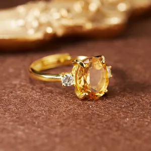 Gros plan sur une bague en argent plaqué or avec une citrine ovale et des pierres latérales