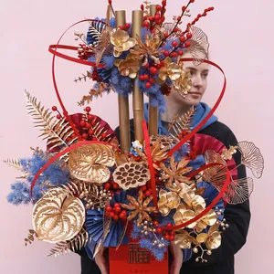Arrangement floral de luxe pour le Nouvel An avec bambou doré et seau traditionnel rouge Fu