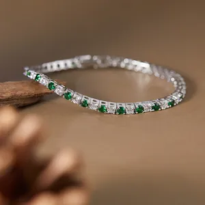 Macro detail of S925 silver tennis bracelet with sparkling green and white gemstones