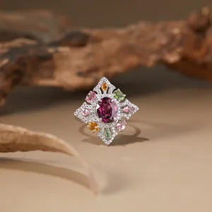 Macro view of S925 silver ring featuring a central purple garnet and colorful gemstones