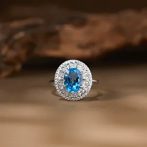 Detailansicht eines S925-Silberrings mit blauem Topas und glitzerndem Heiligenschein.