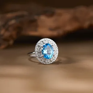 Makroaufnahme eines Rings mit ovalem blauem Topas und filigraner S925 Silberfassung.