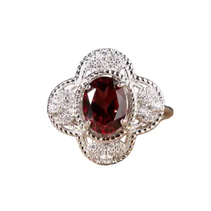 Macro view of a red garnet silver ring with intricate floral setting and crystals