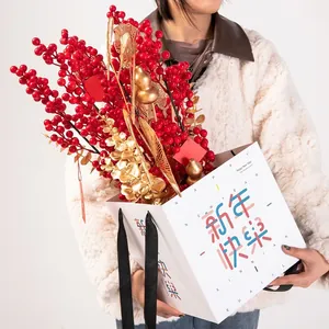Festliche Neujahrs-Geschenktüte aus Papier mit roten Beeren und goldenen Dekorationen