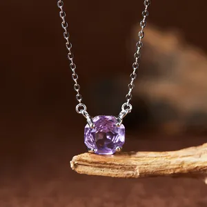 Macro view of a purple amethyst pendant on a sterling silver necklace chain.