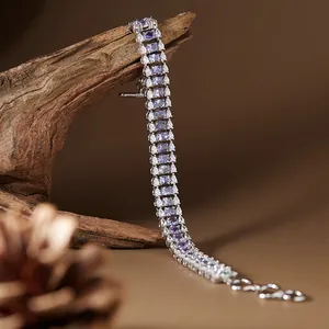 Vue détaillée d'un bracelet en argent S925 avec des pierres violettes ovales sur bois rustique