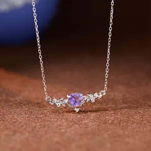 Gros plan d'une améthyste violette en forme de cœur sur un collier en argent à motif de feuilles