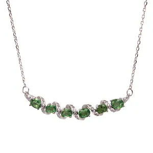 Detalle de collar de barra retorcida de plata S925 con piedras tsavoritas verdes