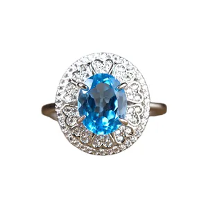 Detaillierte Makroansicht eines ovalen blauen Topasrings mit Herz-Filigran-Design