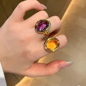 Detailed view of yellow citrine and purple amethyst bathtub rings in gold finish