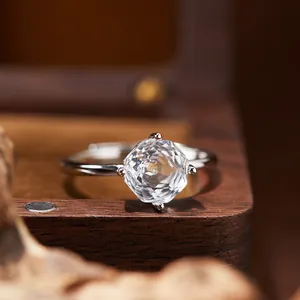 Close-up macro view of a faceted white crystal sterling silver ring on a vintage wooden box