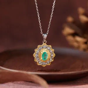 Macro detail of a vintage emerald floral pendant necklace with gold and silver plating