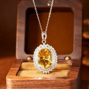 Close-up of large citrine pendant with sparkling pavé border in silver setting.