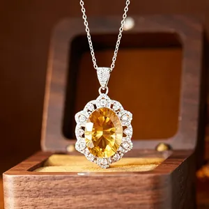 Gros plan détaillé d'un collier avec pendentif en cristal jaune dans un écrin en bois