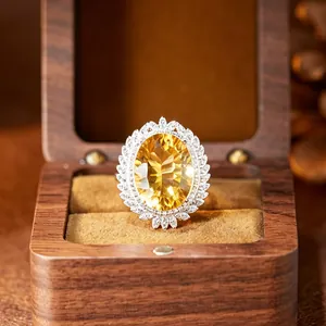 Macro view of a large oval yellow citrine ring with halo set in a luxury wooden gift box