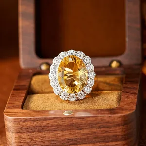 Gros plan d'une grande bague ovale en citrine jaune avec taille en boîte en bois