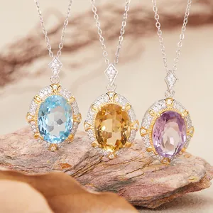 Detailed macro view of oval natural topaz, citrine and amethyst gemstone pendants in silver