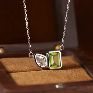 Close-up of S925 silver necklace with emerald-cut green and pear-cut clear gemstones